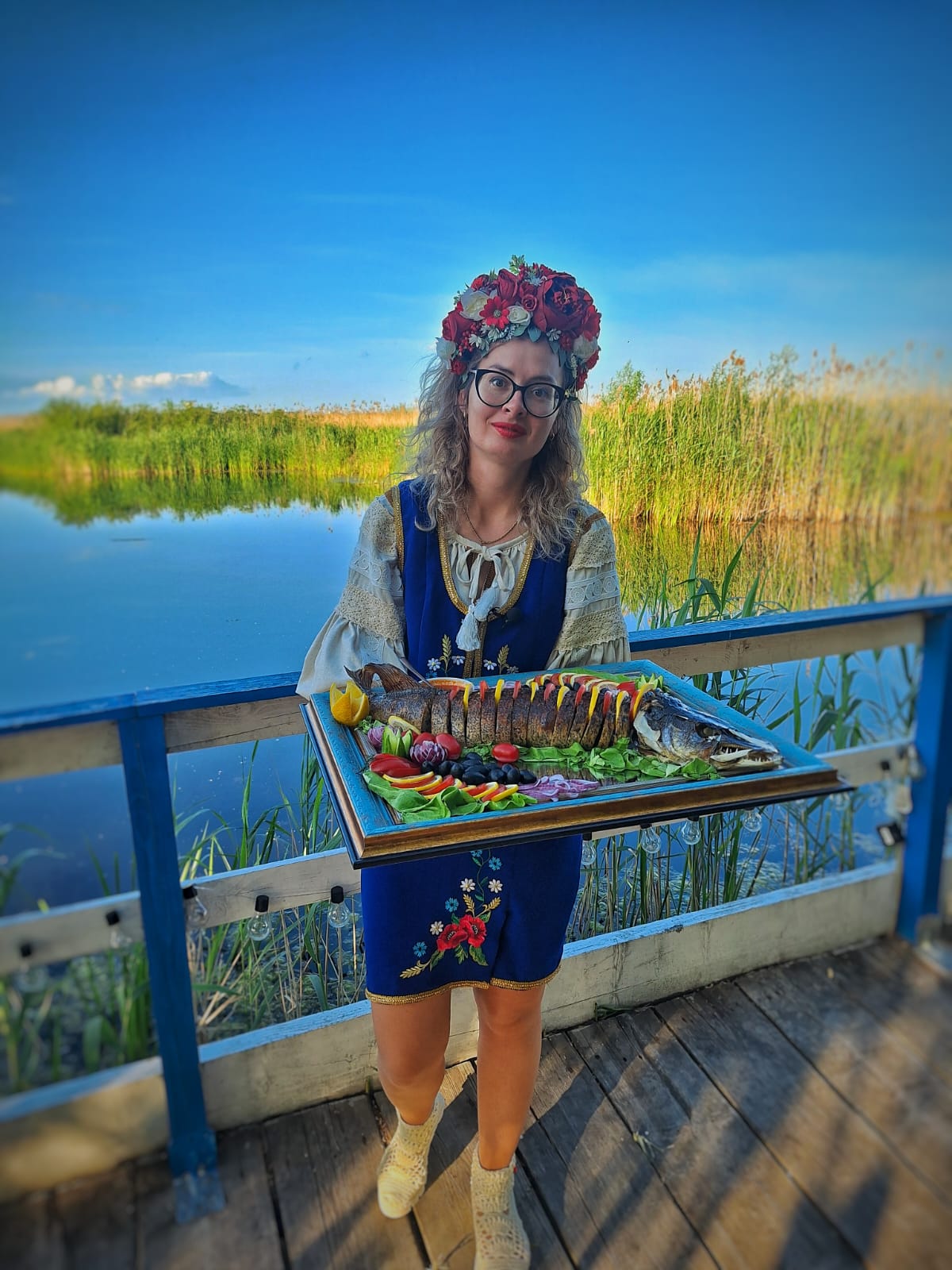 Hostess presenting a whole baked Delta fish on the terrace