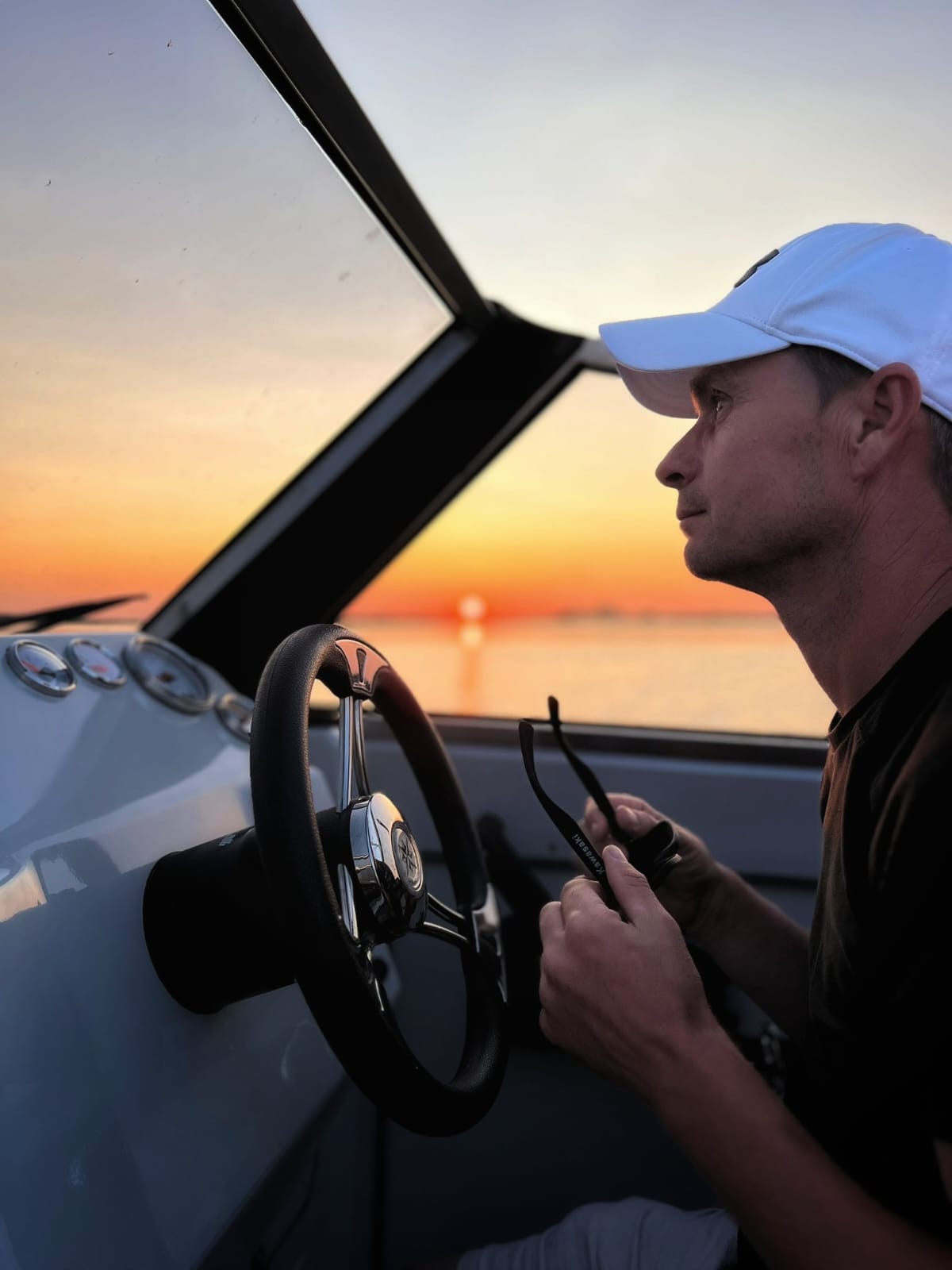 Captain steering at sunset