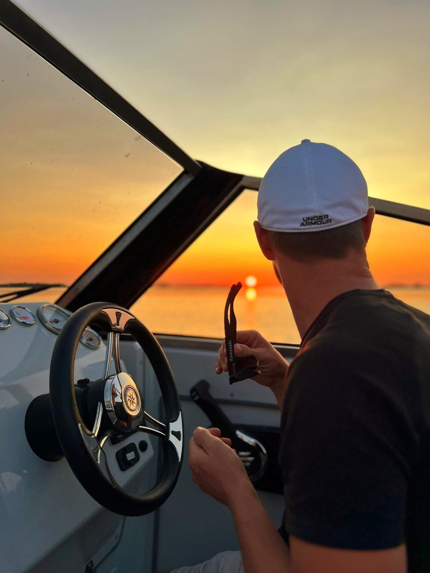 Captain at the wheel facing the sunset